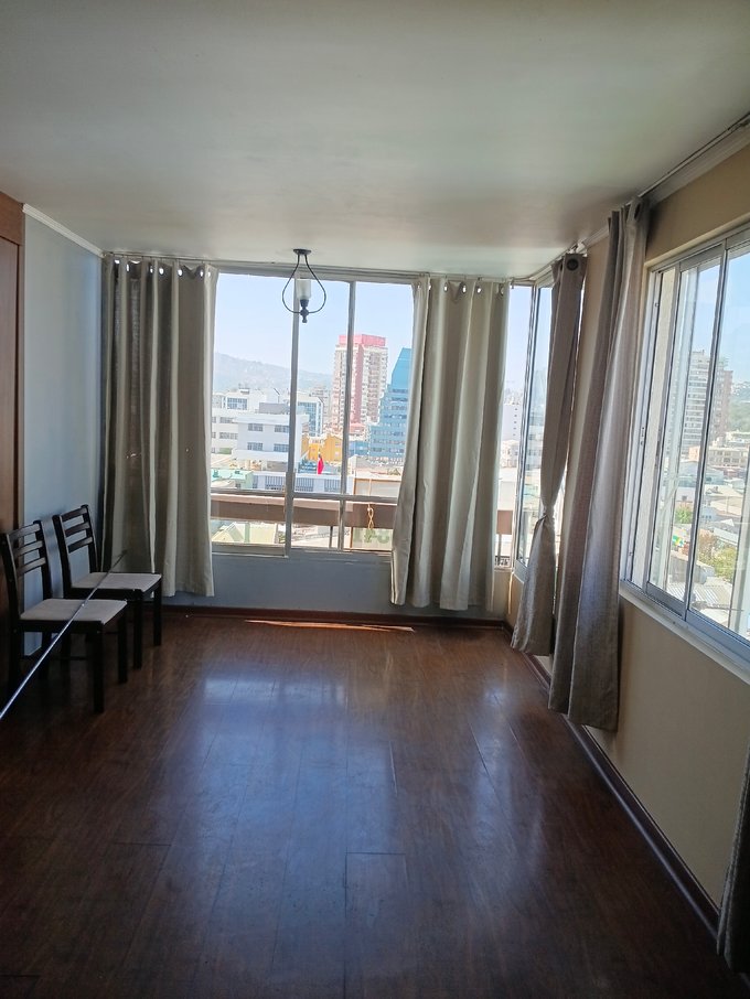 Living comedor, ventanales con cortinas térmicas y lámpara
