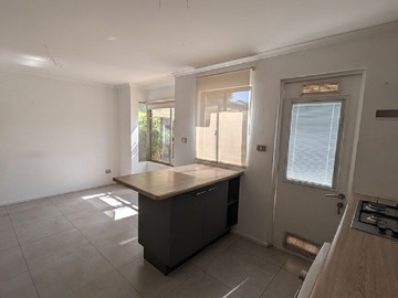 27.- Cocina hacia isla y comedor - vista patio frontal.