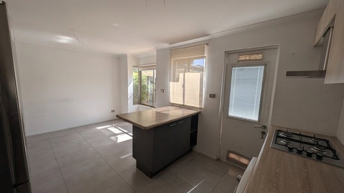 27.- Cocina hacia isla y comedor - vista patio frontal.