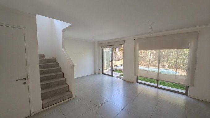 28.- Living amplio vista patio y piscina.