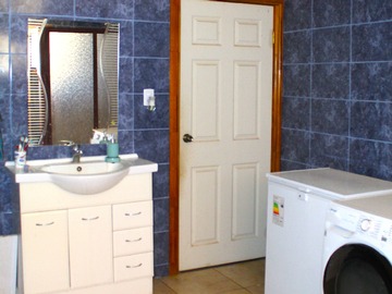 Fotografía interior amplio baño con área de lavadero