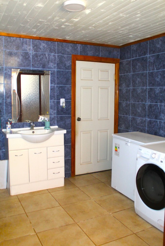 Fotografía interior amplio baño con área de lavadero