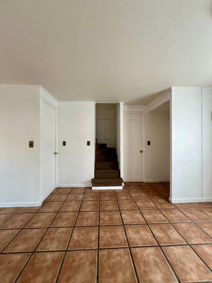 vista hacia la escalera, baño de visitas y cocina cerrada