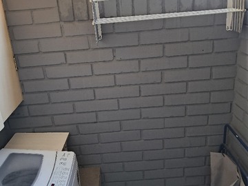 Logia con mueble de guardado, lavadora y tendedero